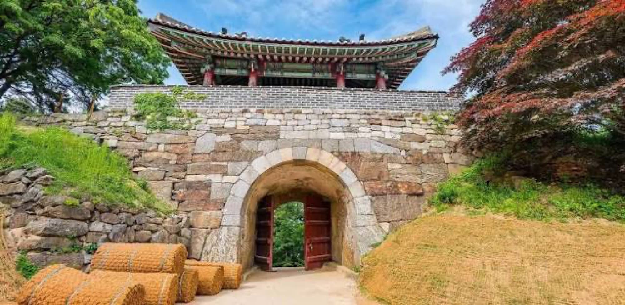 A traditional stone gate with a tiled roof pavilion above it, Gwangju